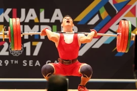 VĐV Thạch Kim Tuấn thi đấu chung kết nội dung Cử tạ hạng 56 kg nam. (Ảnh: Quốc Khánh/TTXVN)