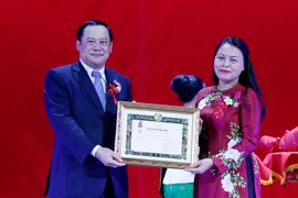 Đồng chí Sonesay Siphandone trao quyết định tặng thưởng Huân chương Itsara hạng 2 cho đồng chí Nguyễn Thị Thu Hà, Chủ tịch Hội LHPN Việt Nam. (Ảnh: Phạm Kiên/TTXVN)