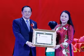 Đồng chí Sonesay Siphandone trao quyết định tặng thưởng Huân chương Itsara hạng 2 cho đồng chí Nguyễn Thị Thu Hà, Chủ tịch Hội LHPN Việt Nam. (Ảnh: Phạm Kiên/TTXVN)