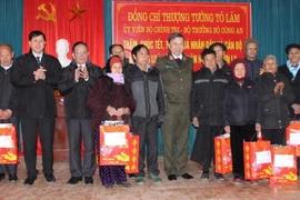 Bộ trưởng Bộ Công an Tô Lâm và lãnh đạo tỉnh Sơn La tặng quà các gia đình có công với cách mạng tại xã Lóng Luông, huyện Vân Hồ, tỉnh Sơn La. (Ảnh: Nguyễn Cường/TTXVN)