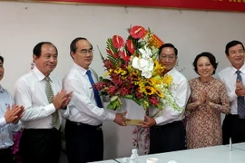 Đồng chí Nguyễn Thiện Nhân tặng hoa chúc mừng đến tập thể cán bộ-viên chức Sở Y tế Thành phố Hồ Chí Minh. (Ảnh: Thế Anh​/TTXVN)