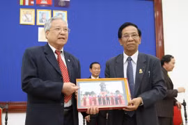 Đại tá Trịnh Vinh Pha, Phó chủ tịch Trung ương Hội hữu nghị Việt Nam-Campuchia (trái) và Phó chủ tịch thứ nhất Thượng viện Campuchia Sim Ka cùng trao quà lưu niệm. (Ảnh: TTXVN)