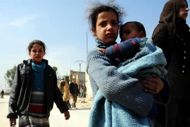 Người dân Syria rời khỏi khu vực chiến sự Hamouriyeh ở Đông Ghouta ngày 17/3. (Nguồn: THX/TTXVN)