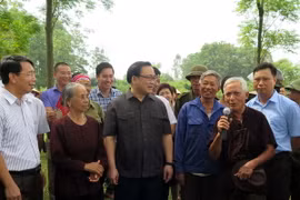 Bí thư Thành ủy Hà Nội Hoàng Trung Hải trao đổi với nông dân chăn nuôi bò trên địa bàn xã Tòng Bạt, huyện Ba Vì. (Ảnh: Nguyễn Văn Cảnh/TTXVN)