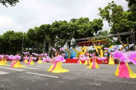 Trình diễn tiết mục múa hoa đào tại Lễ hội Tinh hoa Hà Nội-Hội tụ và tỏa sáng tại phố đi bộ hồ Hoàn Kiếm. (Ảnh: Thành Đạt/TTXVN)
