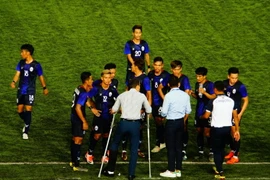 Huấn luyện viên U22 Campuchia (chống nạng) chỉ đạo các cầu thủ. (Ảnh: TTXVN) 