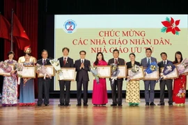 Phó Thủ tướng Vũ Đức Đam trao tặng Danh hiệu Nhà giáo Ưu tú của Chủ tịch nước cho các cá nhân. (Ảnh: Văn Điệp/TTXVN) 