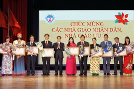 Phó Thủ tướng Vũ Đức Đam trao tặng Danh hiệu Nhà giáo Ưu tú của Chủ tịch nước cho các cá nhân. (Ảnh: Văn Điệp/TTXVN) 
