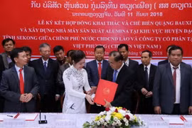 Bộ trưởng Kế hoạch và Đầu tư Lào, ông Suphan Keomisay và bà Phương Minh Huệ, Tổng Giám đốc Tập đoàn đầu tư Việt Phương đang trao cho nhau Hợp đồng tại lễ ký. (Ảnh: Kiên Phạm/Vietnam+)