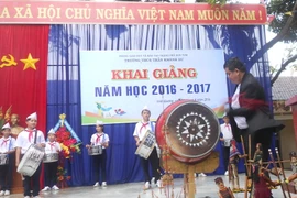 Thầy hiệu trưởng Trần Hữu Lộc đánh trống khai giảng năm học. (Ảnh: Hồng Điệp/Vietnam+)