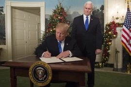 Tổng thống Mỹ Donald Trump (trái) ký tuyên bố công nhận Jerusalem là thủ đô của Israel tại Washington DC., ngày 6/12. (Nguồn: AFP/TTXVN)