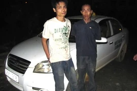 Hai tên cướp bên chiếc xe tang vật. (Ảnh: Chu Quốc Hùng)