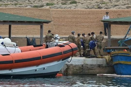 Đưa thi thể nạn nhân của vụ lật tầu vừa được tìm thấy lên bờ. (Nguồn: AFP/TTXVN)