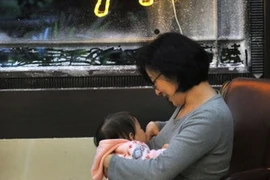 Một bà mẹ đang cho con bú ở một quận của thành phố Đài Bắc. (Nguồn: AFP/Vietnam+)