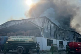 Lực lượng chức năng khẩn trương dập tắt đám cháy. (Ảnh: TTXVN phát)