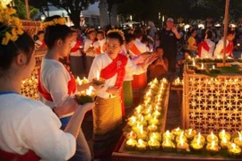 Nghi lễ thắp đèn “phang pateet” tượng trưng cho sự mở ra ánh sáng của sự sống. (Ảnh: TTXVN phát)