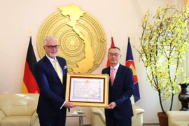 Đại sứ Vũ Quang Minh trao tặng Huân chương Hữu nghị cho Tiến sỹ Guido Hildner, nguyên Đại sứ Cộng hòa Liên bang Đức tại Việt Nam. (Ảnh: Thu Hằng/TTXVN)
