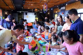 Các em nhỏ say sưa vẽ mặt nạ. (Ảnh: CTV Hải An/Vietnam+)