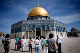 Khách du lịch chụp ảnh bên ngoài Thánh đường Hồi giáo tại thành cổ Jerusalem. (Ảnh: AFP/TTXVN)