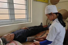 Nhân viên y tế tại trạm y tế xã khám sức khỏe cho người dân. (Ảnh: T.G/Vietnam+)