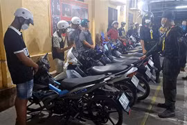 Các đối tượng đua xe bị tạm giữ. (Ảnh: TTXVN phát)