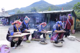Những phụ nữ Mông tranh thủ vẽ mọi lúc khi có thời gian rảnh, ở mọi nơi khi có bếp lửa và khi sáp ong đã nóng chảy, đặc biệt là những lúc nông nhàn. (Ảnh: Tuấn Anh/TTXVN)