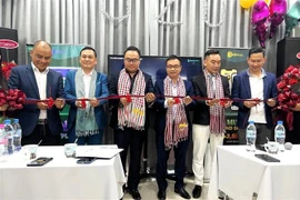 Các đại biểu thực hiện nghi thức cắt băng khai trương Văn phòng U2U tại Campuchia. (Ảnh: Hoàng Minh/TTXVN)