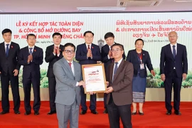 Tổng giám đốc Vietjet Đinh Việt Phương (trái) nhận Chứng nhận mở đường bay TP.HCM-Vientiane từ Phó Tổng Cục trưởng Cục Hàng không Dân dụng Lào Bounteng Symoon. (Ảnh: Doãn Tấn/TTXVN)