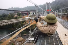 Công nhân đang tiến hành thi công cầu treo dân sinh. (Ảnh: Việt Hùng/Vietnam+)