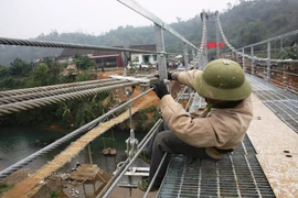 Công nhân đang tiến hành thi công cầu treo dân sinh. (Ảnh: Việt Hùng/Vietnam+)