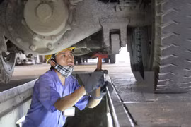 Đăng kiểm viên đang kiểm tra hệ thống gầm ôtô. (Ảnh: Hoàng Hùng/TTXVN)