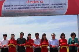 Các đại biểu cắt bắt thông xe 2 cầu Bút Sơn và cầu Thắm trên Quốc lộ 10. (Ảnh: Việt Hùng/Vietnam+)