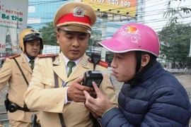 Cảnh sát giao thông tiến hành đo nồng độ cồn của người điều khiển phương tiện. (Ảnh: Việt Hùng/Vietnam+)