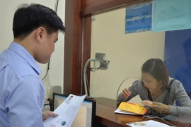 Người dân hào hứng đến đăng ký, làm thủ tục cấp giấy phép lái xe quốc tế. (Ảnh: Việt Hùng/Vietnam+)