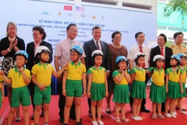 Các đại biểu đội mũ an toàn giao thông cho trẻ em để bảo vệ tính mạng. (Ảnh: Việt Hùng/Vietnam+)