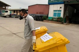 Quy trình giao nhận, xử lý chất thải thực hiện nghiêm ngặt, đảm bảo an toàn cho người lao động. (Ảnh: VH/VIetnam+)