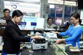 Giao dịch tại ngân hàng. (Ảnh: Vũ Sinh/TTXVN).