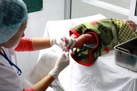 Lấy máu xét nghiệm cho trẻ sơ sinh. (Ảnh minh họa: Dương Ngọc/TTXVN)