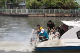 Thả vi sinh zeolite để xử lý môi trường trên kênh Nhiêu Lộc-Thị Nghè. (Ảnh: Thanh Vũ/TTXVN)