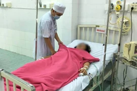 Bác sỹ thăm khám sau phẫu thuật cho bệnh nhân H. (Ảnh: Thanh Sang/TTXVN)