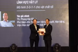 Bộ trưởng Bộ Khoa học và Công nghệ Chu Ngọc Anh (bên trái) trao giải thưởng "Nhà khoa học trẻ có công trình khoa học xuất sắc" cho tiến sỹ Phùng Văn Đồng, Viện Vật Lý, Viện Hàn lâm Khoa học và Công nghệ Việt Nam. (Ảnh: Anh Tuấn/TTXVN)