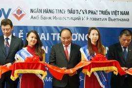 Thủ tướng Nguyễn Xuân Phúc và các đại biểu khai trương Văn phòng Đại diện Ngân hàng Thương mại cổ phần Đầu tư và Phát triển Việt Nam (BIDV) tại Liên bang Nga. (Ảnh: Thống Nhất/TTXVN)