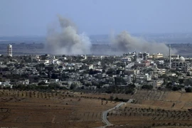 Khói bốc lên từ làng Jubata al-Khashab của Syria sau một vụ không kích của trực thăng quân sự. (Nguồn: AFP/TTXVN)