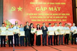 Phó Bí thư Thường trực Đảng ủy Khối các cơ quan Trung ương Lê Mạnh Hùng trao tặng Bằng khen của Đảng ủy Khối cho các cá nhân. (Ảnh: An Đăng/TTXVN)