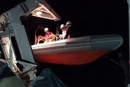 Xuồng cứu hộ đưa các thuyền viên lên tàu SAR 421 an toàn. (Ảnh: Xuân Nguyên/TTXVN)