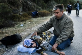 Người tị nạn Syria kiệt sức sau khi vượt Biển Aegean tới đảo Lesbos của Hy Lạp từ Thổ Nhĩ Kỳ. (Nguồn: AFP/TTXVN)