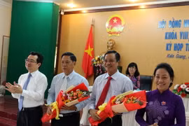 Ông Phạm Vũ Hồng (thứ 2 từ phải sang) nhận hoa chúc mừng. (Ảnh: Lê Huy Hải/TTXVN)