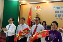 Ông Phạm Vũ Hồng (thứ 2 từ phải sang) nhận hoa chúc mừng. (Ảnh: Lê Huy Hải/TTXVN)