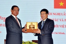 Phó Thủ tướng Phạm Bình Minh và Phó Thủ tướng Campuchia Samdech Krolahom Sar Kheng trao tặng quà lưu niệm. (Ảnh: Thanh Vũ/TTXVN)
