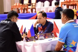 Kỳ thủ Võ Thành Ninh (giữa) thi đấu nội dung Cờ ốc tiêu chuẩn 4 nhóm nam với kỳ thủ của Philippines. (Ảnh: Minh Quyết/TTXVN)
